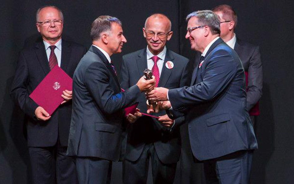 Prezydent Bronisław Komorowski wręcza prezesowi banku PKO BP Zbigniewowi Jagielle nagrodę za ład kor