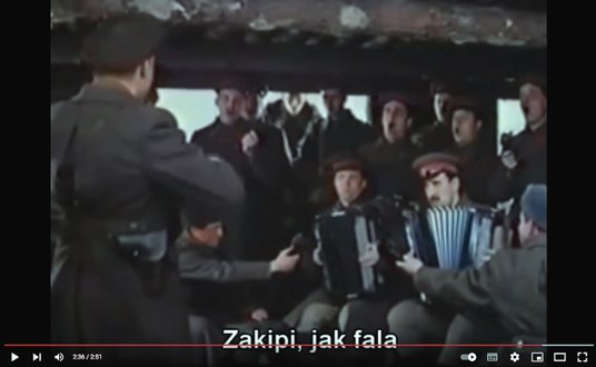 Ściśnięci w bunkrze na zapleczu frontu, dyrygowani przez Aleksandrowa chórzyści śpiewają „Świętą woj