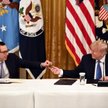 Amerykański sekretarz skarbu Steven Mnuchin prezentuje kartę debetową prezydentowi Donaldowi Trumpow