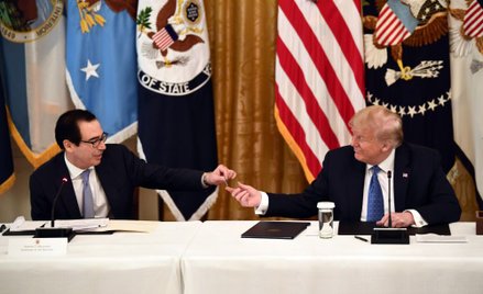 Amerykański sekretarz skarbu Steven Mnuchin prezentuje kartę debetową prezydentowi Donaldowi Trumpow