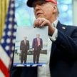 Prezydent USA Donald Trump trzymający własne zdjęcie z Władimirem Putinem