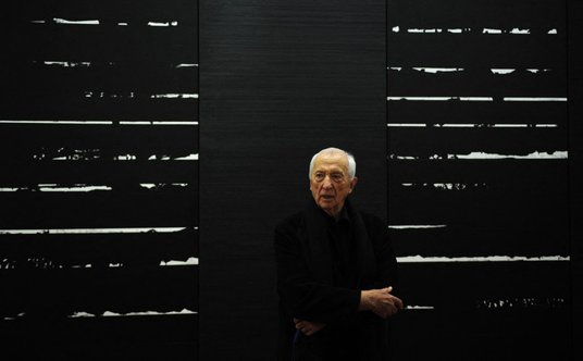 Pierre Soulages pozuje na tle jednej ze swych prac, fot. z 2010 r.