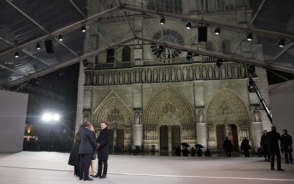 Prezydent Francji Emmanuel Macron wita gości przed rozpoczęciem ceremonii ponownego otwarcia katedry