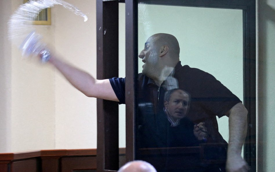 Nika Melia, jeden z liderów opozycyjnej Koalicji na rzecz zmian, próbuje oblać wodą sędzięgo podczas