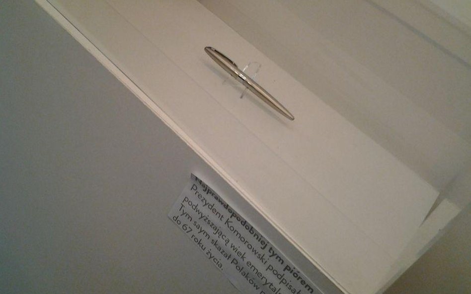 W gablocie jest pióro symbolizujące podpisanie ustawy o podwyższeniu wieku emerytalnego