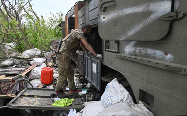 Żołnierz z Ukrainy przy zniszczonym rosyjskim sprzęcie
