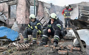 Charkowscy strażacy na ruinach kolejnego domu po ugaszeniu pożaru
