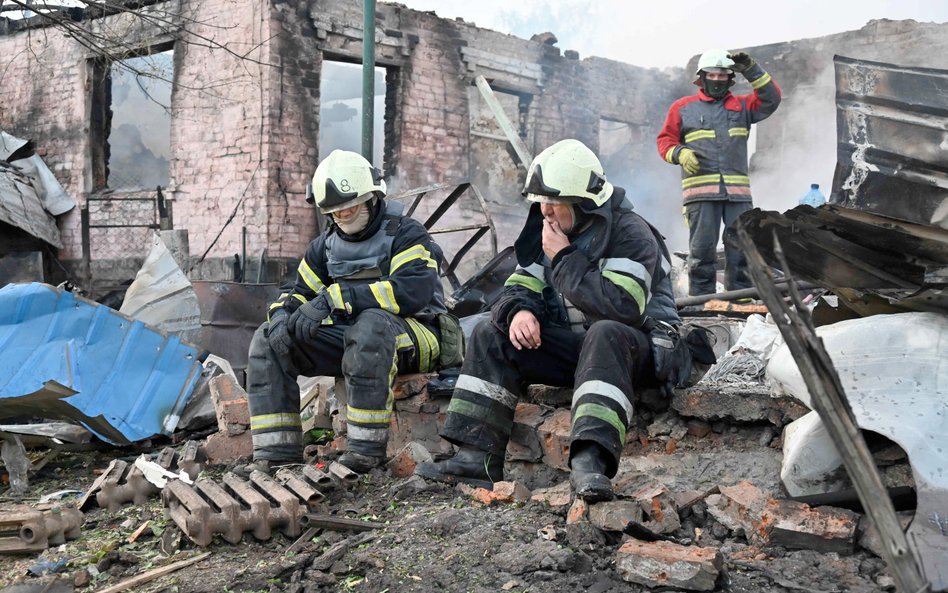 Charkowscy strażacy na ruinach kolejnego domu po ugaszeniu pożaru