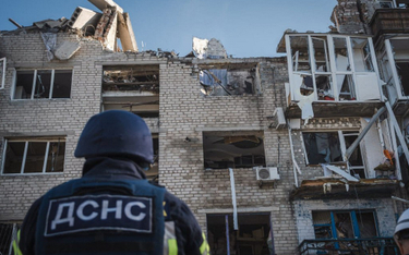 Ukraińskie służby ratunkowe przez częściowo zniszczonym blokiem w Pokrowsku, w obwodzie doniecki,