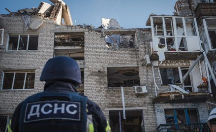 Ukraińskie służby ratunkowe przez częściowo zniszczonym blokiem w Pokrowsku, w obwodzie doniecki,