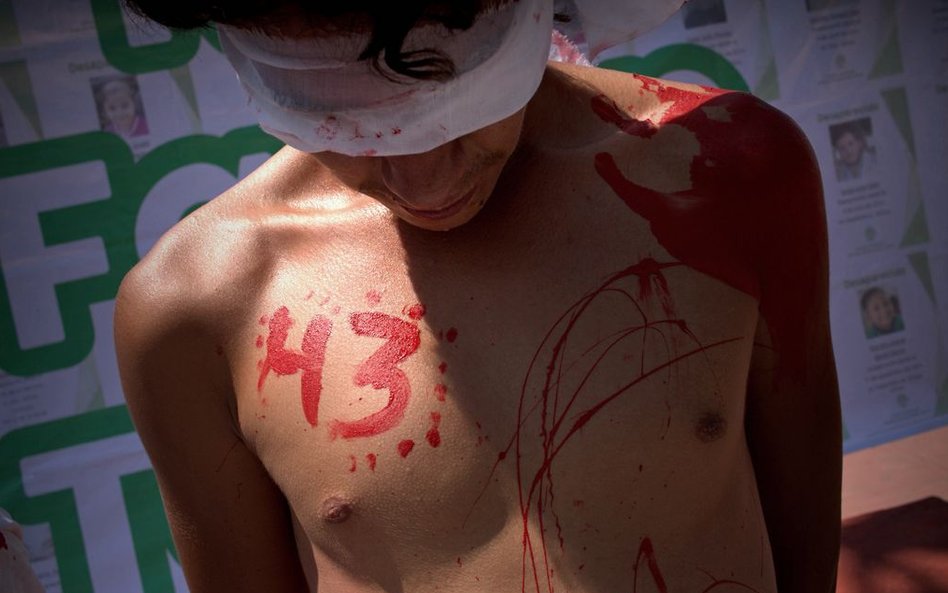 Młody mężczyzna protestuje przeciwko zeszłorocznym zaginięciom i prawdopodobnej śmierci 43 studentów