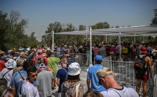 Oczekujący stoją w palącym słońcu