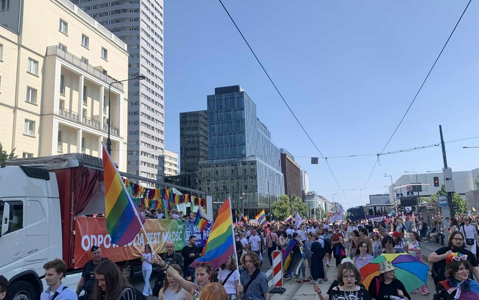 Długi korowód Parady Równości, z licznymi tęczowymi flagami i platformami