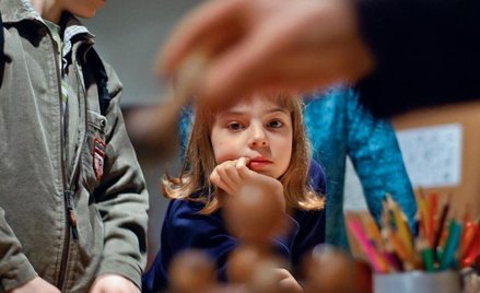 Dzieci z uwagą słuchają opowieści o tym, jak podczas powstania warszawskiego dostarczane były listy