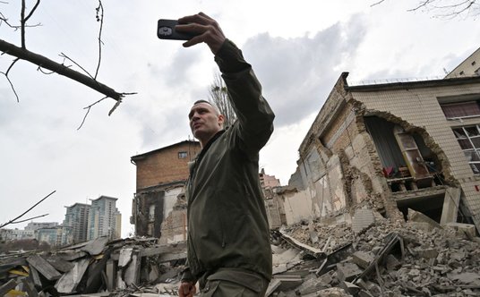 Mer Kijowa Witalij Kliczko przed budynkiem uszkodzonym w wyniku rosyjskiego ataku rakietowego