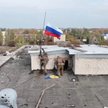Rosyjscy żołnierze umieszczają flagę na dachu budynku w mieście Sełydowe w obwodzie donieckim Ukrain