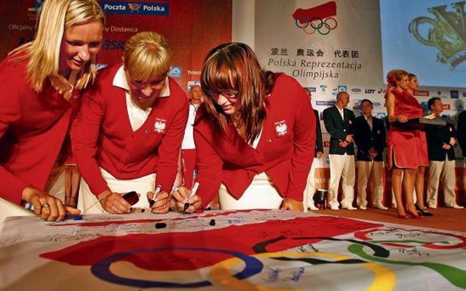 Podpisy na olimpijskiej fladze składają łuczniczki. Od lewej: Małgorzata Ćwienczek, Iwona Marcinkiew