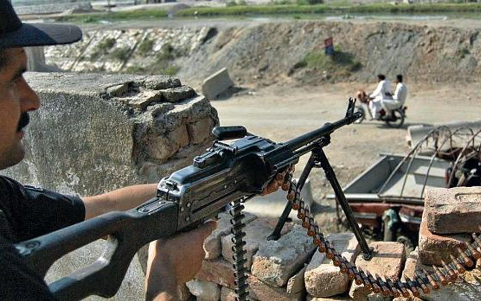 Pakistańska policja pilnuje drogi w okolicach Peszawaru, gdzie często dochodzi do potyczek z talibam