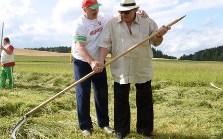 Prezydent Białorusi Aleksander Łukaszenko uczy francuskiego aktora Gerard Depardieu jak używać kosy.