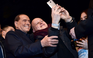 Silvio Berlusconi, lider Forza Italia, pozuje do seflie na spotkaniu wyborczym w Mediolanie