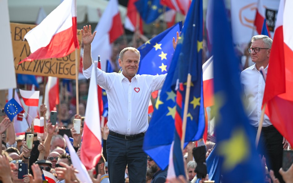 Przewodniczący PO Donald Tusk i prezydent Poznania Jacek Jaśkowiak w czasie wiecu. W tle transparent