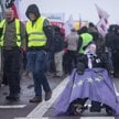 Słomiany manekin z twarzą komisarza UE ds. rolnictwa Janusza Wojciechowskiego siedzi na wózku inwali