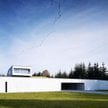 Rozwiązanie z ukrytym wjazdem do domu to wynik ukształtowania działki, która ma spory spadek. Archit