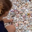 Osoby odwiedzające miejsce pamięci kładą kamyki ku czci ofiar masowej strzelaniny na plaży Bondi