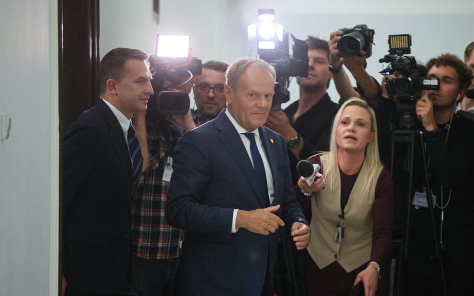 Premier Donald Tusk (C) i rzecznik rządu Adam Szłapka (L) w Sejmie w Warszawie