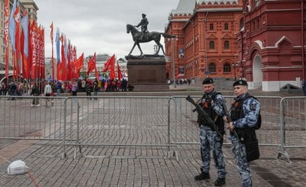 Funkcjonariusze policji przed barierami chroniącymi Plac Czerwony w Moskwie na dzień przed paradą w 