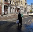 Kobieta na ulicy zniszczonego bombardowaniami i ostrzałem Charkowa