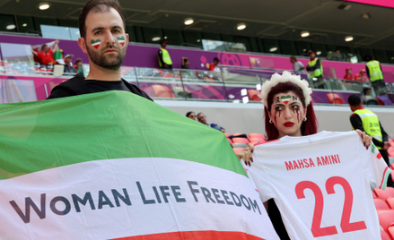 Fan Iranu z flagą z hasłem "Kobieta, Życie, Wolność"