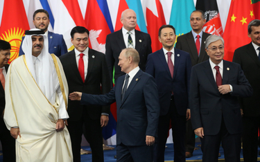 Emir Kataru Tamim bin Hamad al-Thani (z lewej) i Władimir Putin (w środku) podczas politycznego spot