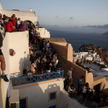 Turyści oglądający zachód słońca w mieście Oia na wyspie Santorini