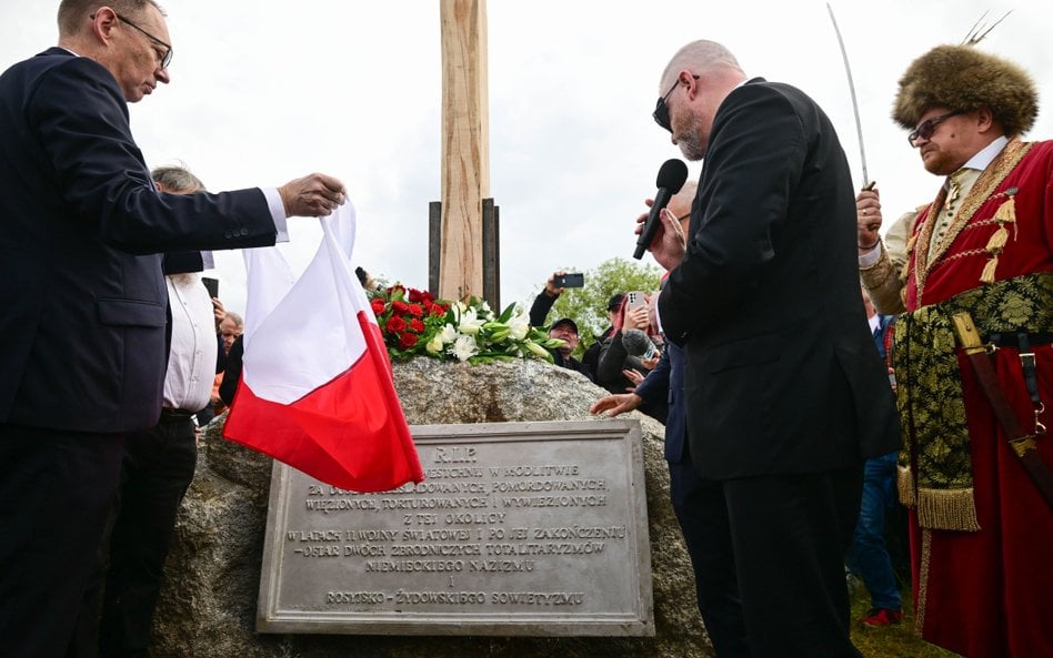 Europoseł Grzegorz Braun (C) podczas odsłonięcia alei pamięci z 8 głazami i tablicami, których treść