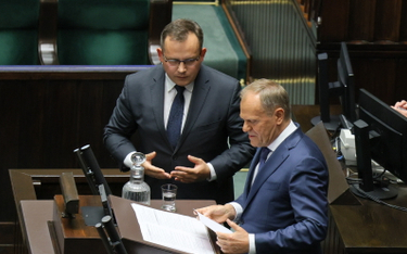 Premier Donald Tusk (P) i poseł PiS Paweł Rychlik (C) na sali obrad Sejmu
