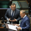 Premier Donald Tusk (P) i poseł PiS Paweł Rychlik (C) na sali obrad Sejmu