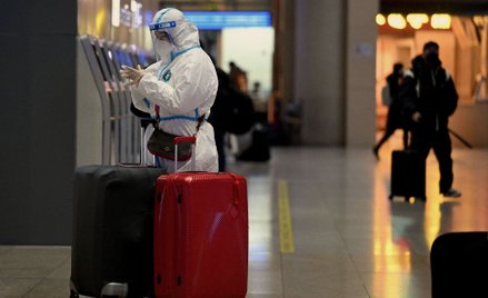 Pasażer na dworcu w Pekinie w odzieży ochronnej