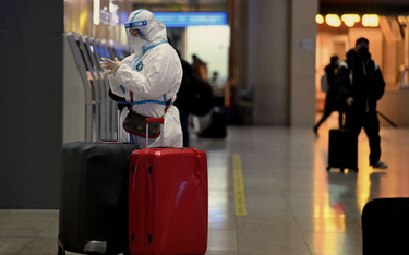 Pasażer na dworcu w Pekinie w odzieży ochronnej