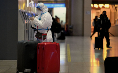 Pasażer na dworcu w Pekinie w odzieży ochronnej