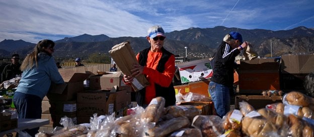 Wolontariusze przygotowują jedzenie dla osób czekających w ponad stu samochodach w kolejce przed pun