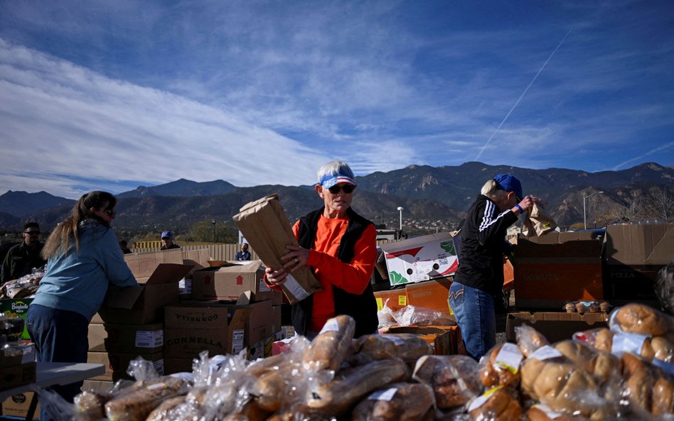 Wolontariusze przygotowują jedzenie dla osób czekających w ponad stu samochodach w kolejce przed pun