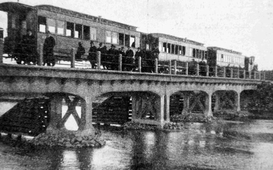 Rok 1914 – pierwszy przejazd pociągu przez rzekę Świder; właściciele kolejki podziwiają most.