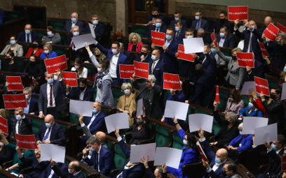 Posłowie Koalicji Obywatelskiej z transparentami na sali obrad Sejmu w Warszawie, 14 grudnia 2021