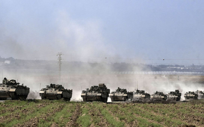 Transportery opancerzone Puma armii izraelskiej przemieszczają się w kolumnie w pobliżu granicy ze S