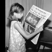 Dziewczynka czyta w "Washington Post" o lądowaniu człowieka na Księżycu
