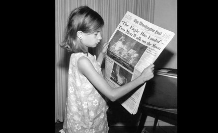 Dziewczynka czyta w "Washington Post" o lądowaniu człowieka na Księżycu