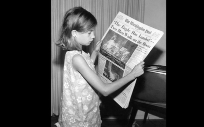 Dziewczynka czyta w "Washington Post" o lądowaniu człowieka na Księżycu