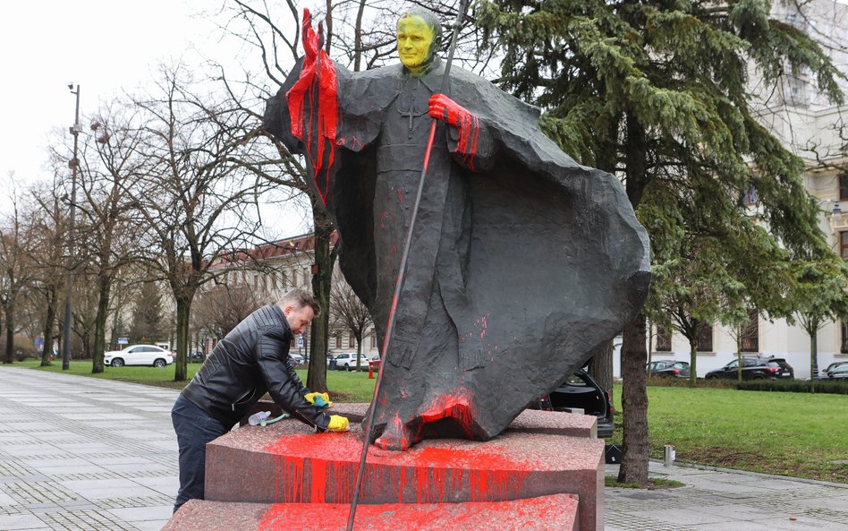 Czyszczenie oblanego farbą pomnika Jana Pawła II stojącego przed bazyliką archikatedralną w Łodzi