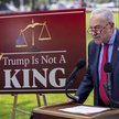 Lider senackiej mniejszości Chuck Schumer obok planszy z napisem „Trump nie jest królem”